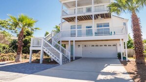 A two-story house with a balcony, a garage, and a staircase leading to the entrance. - All Decked Out w/ private pool, Free Golf, Zipline (Destin)