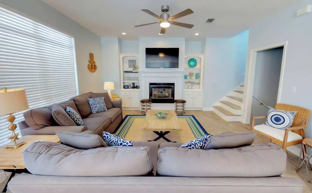 A living room with a sofa set, a coffee table, a TV, and a fireplace.