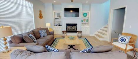 A living room with a sofa set, a coffee table, a TV, and a fireplace.