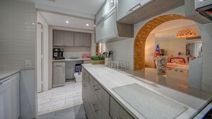 A modern kitchen with a central island, built-in appliances, and a decorative archway.