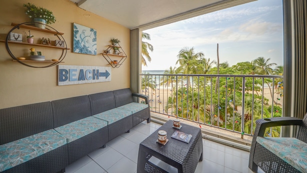 A balcony with a sofa, a table, and decorative shelves.