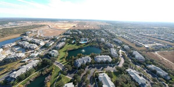 Vista aérea de una zona residencial con casas, un lago y un campo de golf.