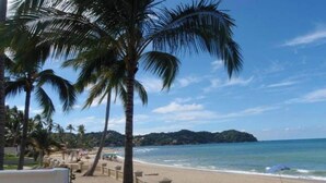 A beach view with palm trees and a clear sky. - Casa Colibri - Los Delfines (Sayulita)