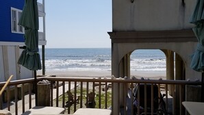 A balcony with a view of the ocean, a wooden deck, and beach chairs. - Beach is 50 steps away and you have PRIVATE beach access and wonderful views (Folly Beach)