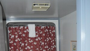 Een badkamer met douchegordijn, toilet, wastafel en betegelde vloer.