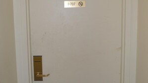 Een witte deur met een messing handvat en een bordje erboven met de tekst 'I-707' en een rookvrij-pictogram.