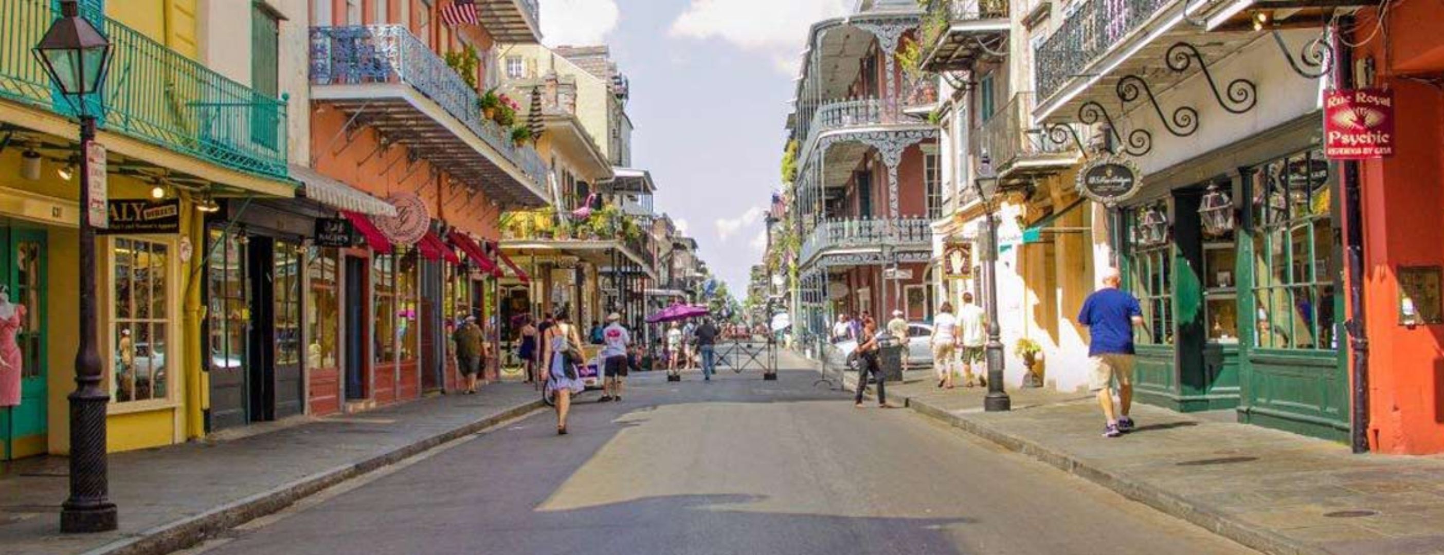 A street lined with colorful buildings, some with balconies and outdoor seating.