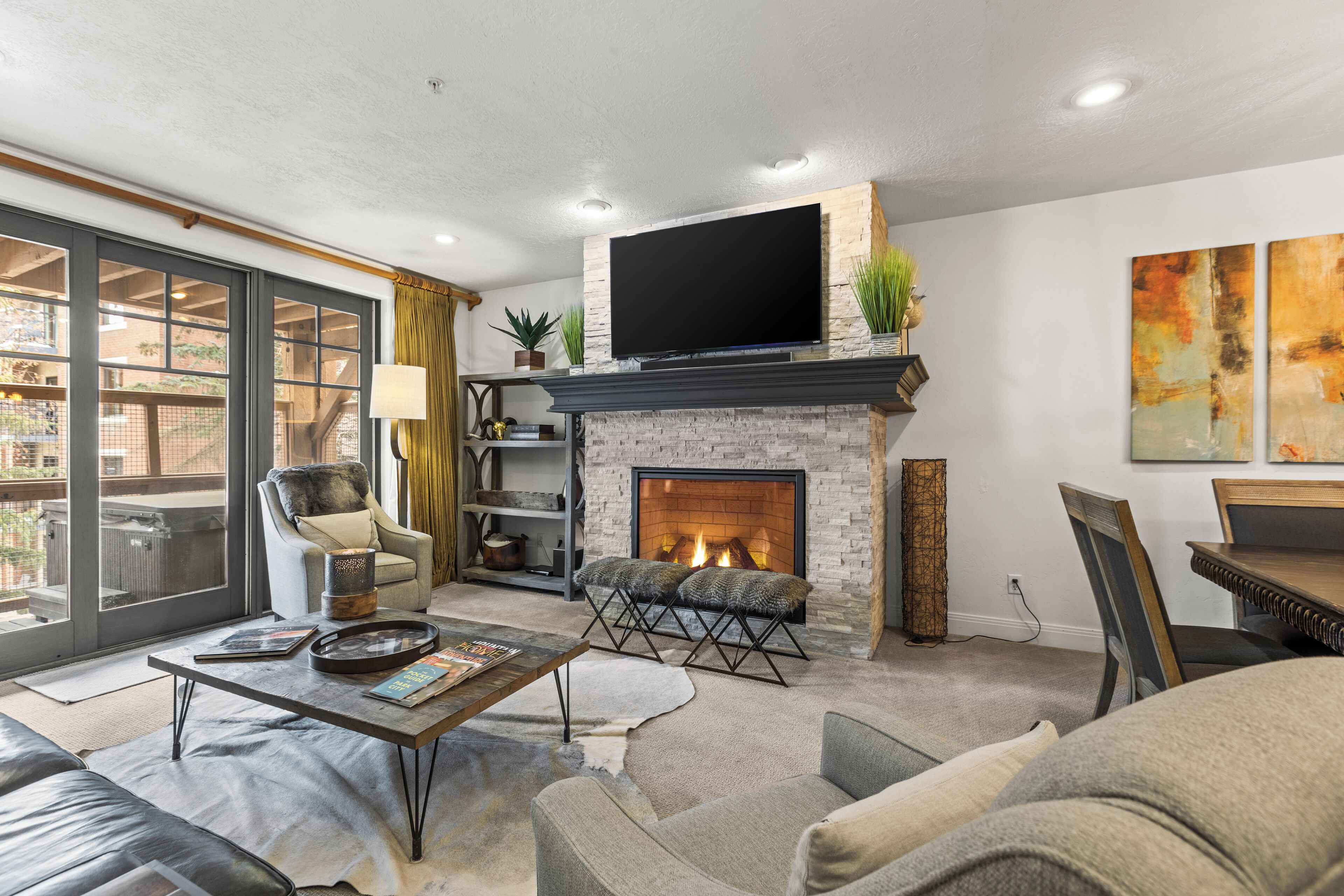 A modern living room with a fireplace, comfortable seating, and a large TV.