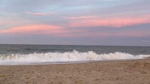 A beach with waves crashing onto the shore under a pink and blue sky. - 5-Star Oceanblock Sleeps 18! Luxury Beach Vacation Home Private Beach Community  (Bethany Beach)