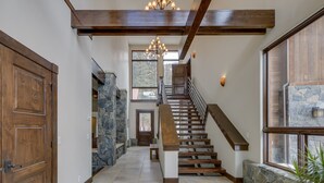 Eine Holzt Treppe mit Steinwänden und einem Chandelier.