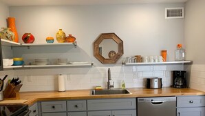 A modern kitchen with grey cabinets, a wooden countertop, a dishwasher, and various kitchen appliances. - Desert Morada Casita G: 2 Bedroom 1 Bath Dog Friendly maximum 2-NO OTHER PETS (Tucson)