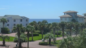 A beachfront property with multiple buildings, palm trees, and a clear view of the ocean.