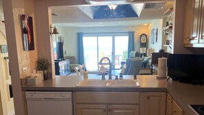 Una cocina equipada con lavavajillas, pileta y estufa. Se puede apreciar una ventana con vista al exterior.