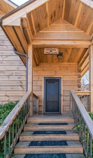 Staircase leads to the entrance of Hidcawing, a rustic cabin-style building.