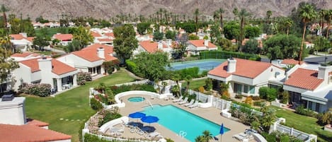 Zona residencial con casas, piscina y cancha de tenis.
