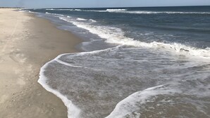 A beach with waves gently lapping onto the shore.