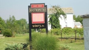Señal para Mastro Pietro Winery, Inc., fundada en 2005, con un viñedo de fondo.