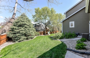 Enjoy the serene outdoor space with a beautifully manicured lawn and a wooden deck.
