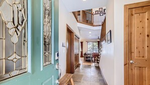 A hallway with a wooden bench, a staircase, and a dining area with a table and chairs. - Breckenridge 3 Bedrm Townhouse, Private Hot Tub, near Golf, Hiking & Bike trails (Breckenridge)