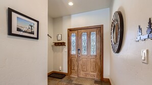 A hallway with a wooden door, a framed picture on the wall, and a decorative mirror. - Breckenridge 3 Bedrm Townhouse, Private Hot Tub, near Golf, Hiking & Bike trails (Breckenridge)