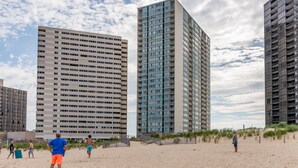 Ein Strand mit hohen Gebäuden im Hintergrund.