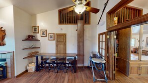 A dining area with a wooden table and chairs, a ceiling fan, and a staircase leading to an upper level. - Brian Head Penthouse South, Pool-Hotub, Ski-i/o, 3 Masters, Play lofts, Sleep 14 (Brian Head)