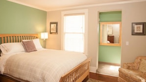 A bedroom with a bed, bedside table, lamp, and a mirror on the wall. - An Unbeatable Location with Historic Character (Santa Barbara)