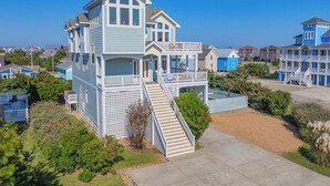 A two-story house with a balcony and a staircase leading to the entrance. - Semi-Oceanfront Dog Friendly w/ Pool, Hot Tub, Elevator, Theater, and Game Room (Salvo)