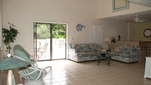 Una sala de estar con un sofá, una silla, una mesa y una planta.