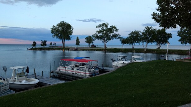 A marina with boats docked, a grassy area, and trees. - Seasonal Fully Furnished Mobile home (Port Austin)