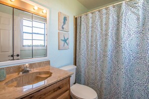 Een bad/douchecombinatie, handdoeken