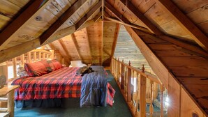 A cozy attic bedroom with a bed, a chair, and a staircase. - Yosemite! Dogs & family! Mountain Air, come visit and make Wonderful Memories! (Oakhurst)