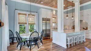 A modern kitchen with white cabinetry, a central island, and pendant lighting.