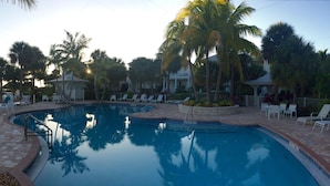 A swimming pool with lounge chairs and palm trees. - Beautiful Islamorada Home In Angler's Reef. Amazing Views. Boatslip Included. (Islamorada)