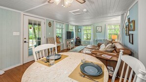 A dining area with a table set for four, a ceiling fan, and a view of the outdoors. - Forget-Me-Knot Cottage at The Wilderness of Mentone adjoins the LRCNP (Mentone)