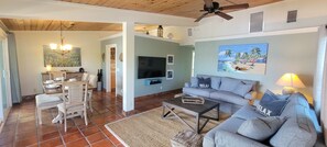 A living room with a sofa, coffee table, TV, and artwork. - 🌴 Coco Plum Paradise 🌴 Private Bayfront Home • Pool • Hot Tub • Dock • View (Marathon)