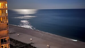 A beachfront hotel with multiple balconies overlooking the ocean, a clear view of the sea, and a well-lit building facade. - 14th FL, 2312 Sq Ft, Luxury Gulf Front,  corner 3BR/4BA, plus bonus den, amazing (Pensacola)