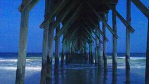 A wooden pier extending into the ocean with a clear view of the water and waves. - Amazing Ocean & Bay Views Beach access is feet away Heated Pool Hot Tub Tiki Bar (North Topsail Beach)