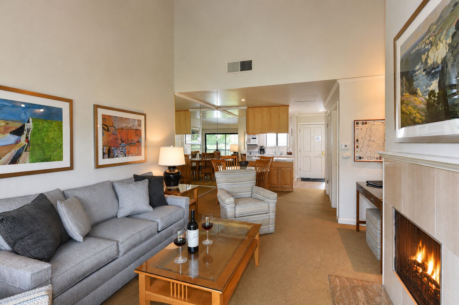 A living room with a sofa, armchairs, a coffee table, and a fireplace.