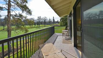 A balcony with a view of a green landscape and trees.
