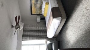 Ein Hotelzimmer mit Bett, Deckenventilator, Fenster und Blick nach draußen.