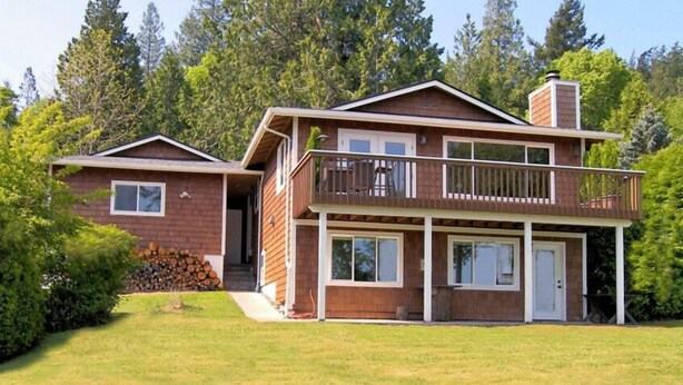 A two-story house with a balcony and a covered porch.