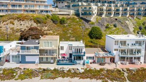 Un hotel frente al mar con varios balcones, piscina y vistas a la playa.