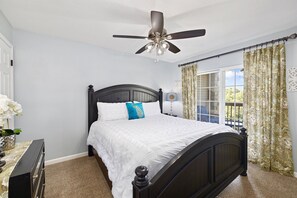 A bedroom with a bed, a ceiling fan, a dresser, a window with curtains, and a view of the outdoors. - NO STAIRS•Next to SDC & Table Rock Lake•King Master• 2beds 2baths•20ft Patio (Branson)