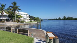 A waterfront property with a dock, a gazebo, and a white building with balconies.