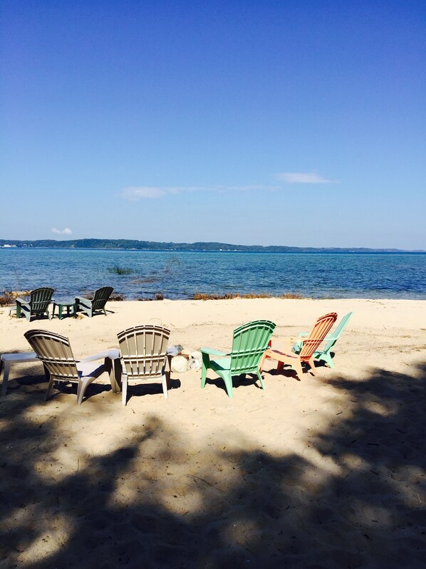 Relax in comfort on the beach with Adirondack chairs arranged for a serene seaside experience.