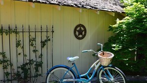A blue bicycle with a basket, parked in front of a yellow building with a star emblem. - Historic Downtown │Walk Everywhere │Private Hot Tub │One Block to River (Bend)