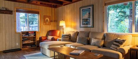 A cozy living room with a sofa, a coffee table, and a bookshelf.