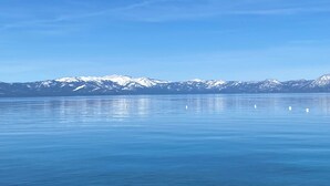 Un lago tranquilo con montañas nevadas al fondo.