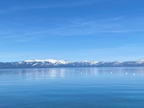 Un llac tranquil amb muntanyes nevades al fons.